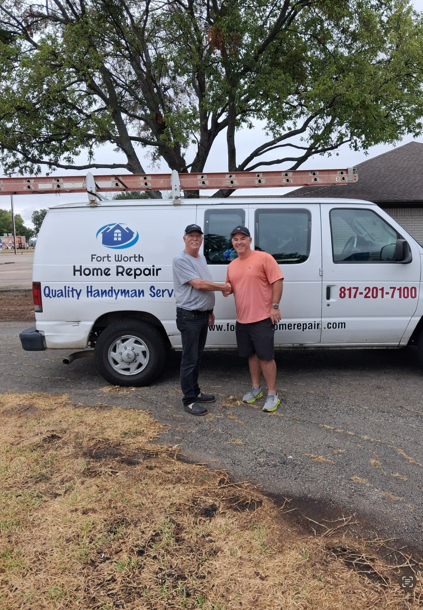 David Luttrell, left, and Kyle Denmark shake hands in front of the Fort Worth Home Repair van